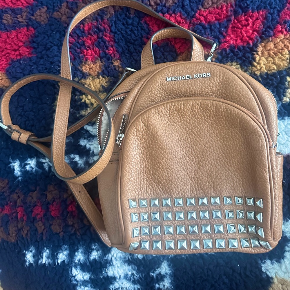 Small brown leather Michael kors backpack with silver.